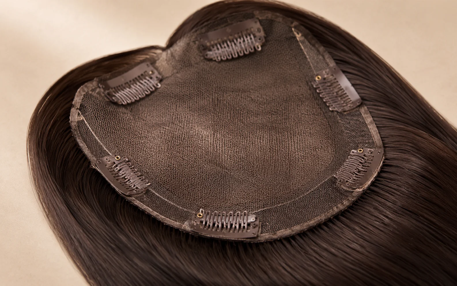 Closeup of soft pressure clips on a clip in hair topper base