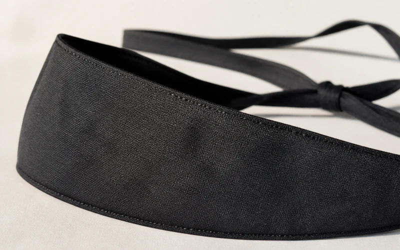 Close-up of a shpitzel band showing finished edges, wrapped surface texture, and rear tie closure