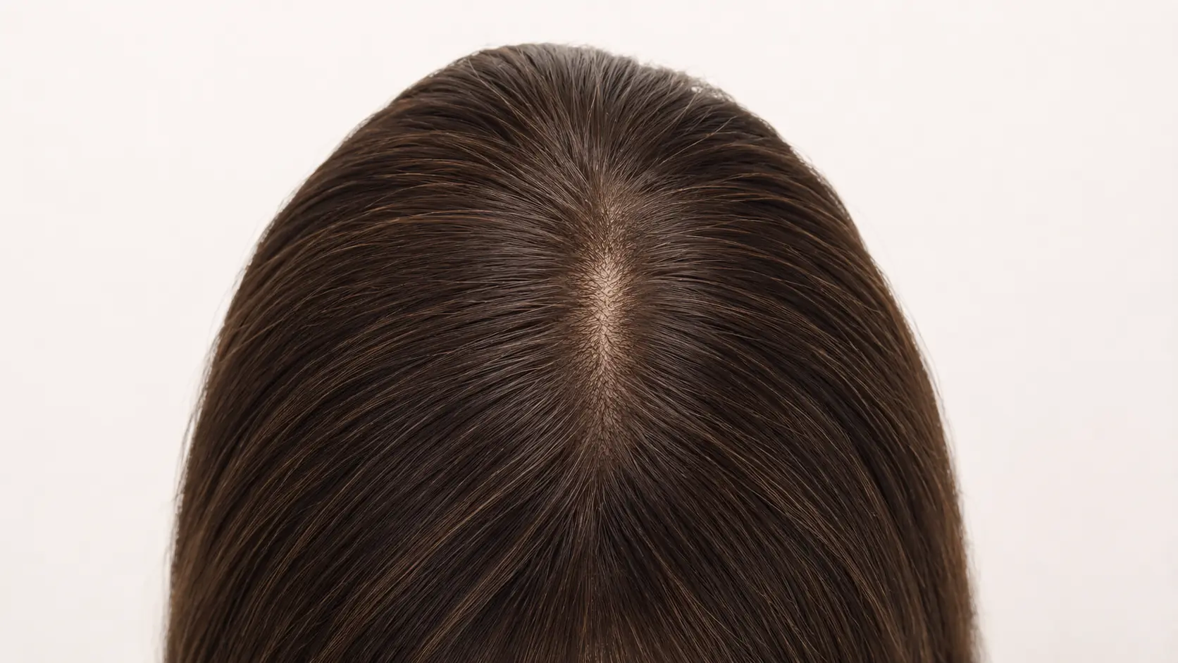 Top view of a brunette lace top sheitel focused on the crown parting area